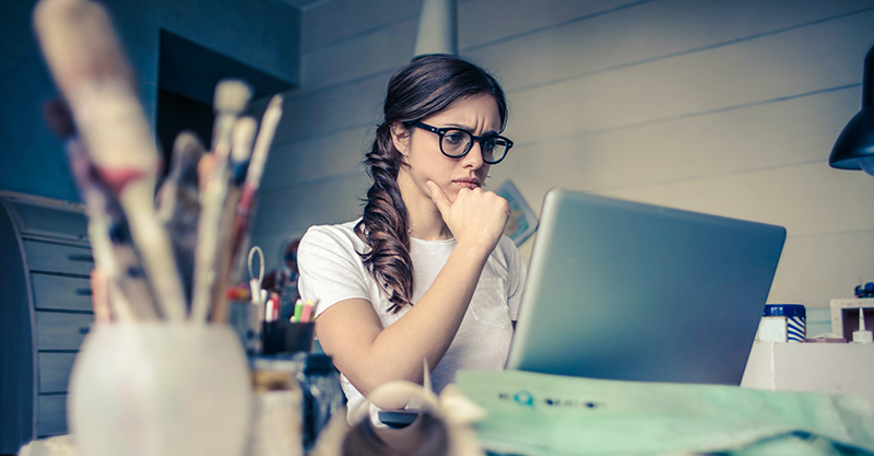 a girl thinking in front of the laptop